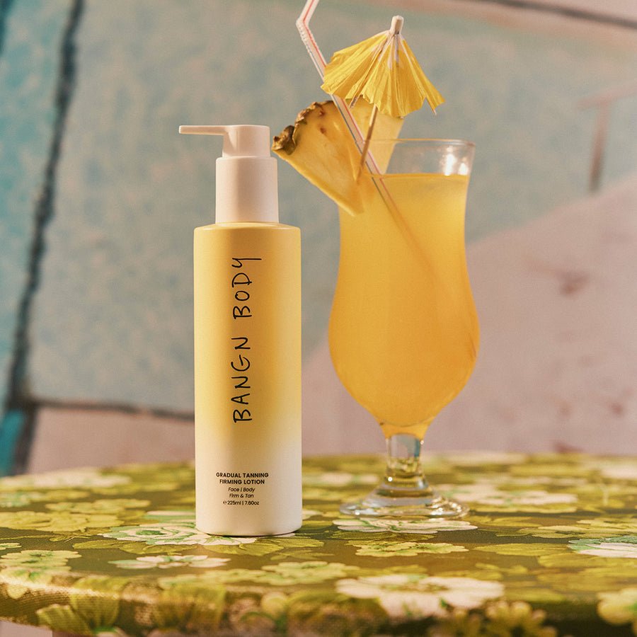 Bangn Body Gradual Tanning Firming Lotion 225ml manufacturer product photograph beside pineapple drink